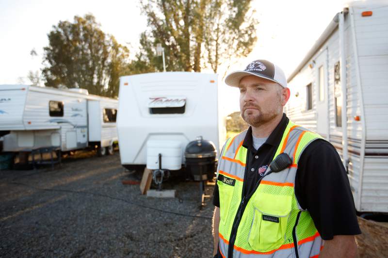 Michael Wolff, wearing a reflective vest, stands in front of a group of trailers.
